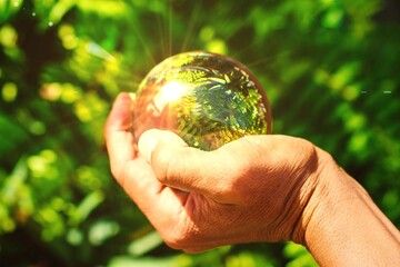 Hand holding crystal ball sunlight shine bright global warming day concept earth protection banner