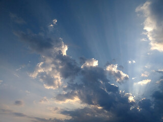 Dramatic clouds and sunlight rays over blue sky. Perfect for spiritual and religious concepts.