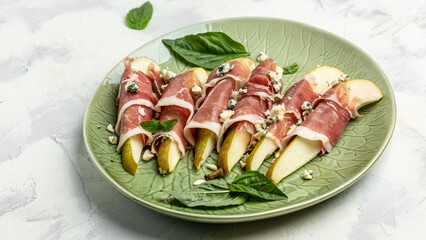 Appetizer with pear, blue cheese and prosciutto ham on a dark background, Healthy fats, clean...