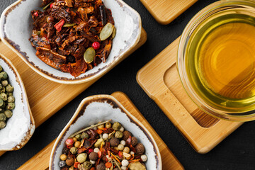 Oil, herbs and spices on wooden background