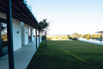 View of grassy land in yard in front of nursing home against clear sky, copy space
