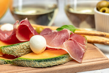 Fresh melon with prosciutto and basil. Antipasti, Traditional Spanish and Italian appetizer. Top view
