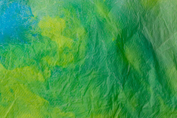 Background of crumpled green paper. Wrinkled paper close-up