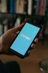searches the text long covid in his smartphone