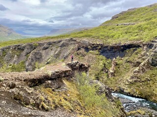 Woman looking at Glymur waterfall, second highest waterfall of Iceland.