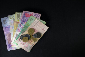 Ukrainian hryvnia of various denominations banknotes and coins on a black background