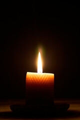 Close up single candle light and flame on black background