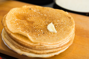 process of baking pancakes in pans on kitchen stove. stack of hot pancakes