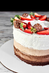 Close up of summer dessert ice cream strawberry cake with chocolate on a white wooden table