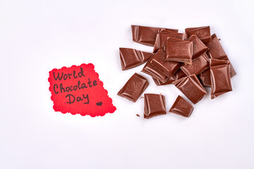 World chocolate day concept. Pile of dark chocolate pieces. Isolated on white background.