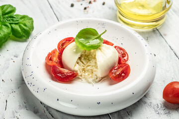 fresh soft white burrata cheese ball made from mozzarella and cream from Apulia, Italian Mediterranean cuisine, Food recipe background. Close up
