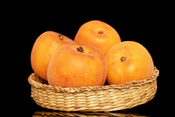 Several ripe sweet apricots with a straw plate, close-up, isolated on a white background.