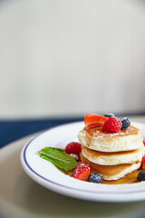 Panqueques japoneses con frutos rojos y maple syrup. Delicioso brunch en restaurante