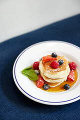 Pancakes japoneses con maple syrup y frutos rojos. Brunch en restaurante