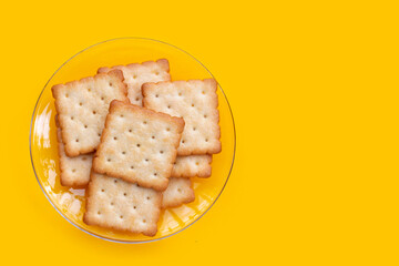 Dry cracker cookies on yellow background.