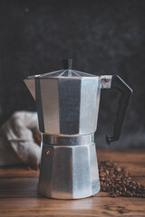 Old steel coffee pot on the wooden table and black background