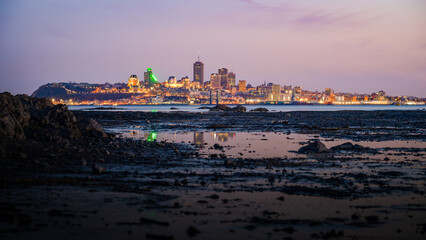 Obraz premium Vantage viewpoint at low tide over Quebec city's coast at blue hour viewed from Île d'Orléans, Quebec, Canada