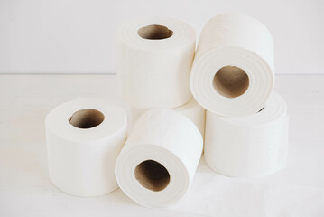 Rolls of white toilet paper on a white background