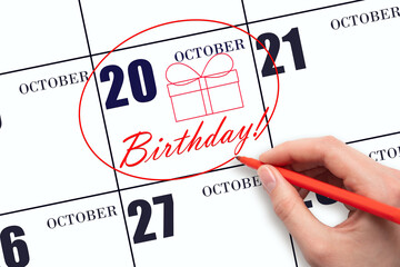 The hand circles the date on the calendar 20 October, draws a gift box and writes the text Birthday. Holiday.