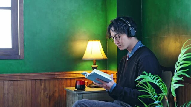 暗い部屋で本を読む男性