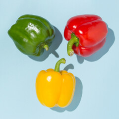 Three colorful peppers on pastel background. Colors of nature concept.
