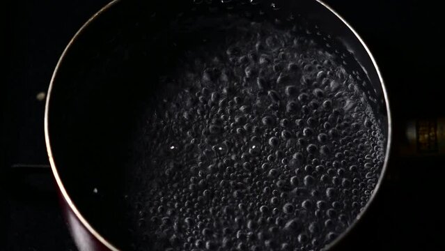 鍋のお湯がコンロで温められて沸騰している様子