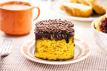 carrot cake with chocolate sprinkles, served with coffee with milk and toasted bread, typical afternoon sweet made in Brazil
