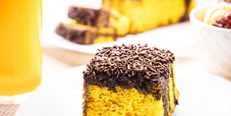slice of carrot cake with creamy chocolate icing and sprinkles, typical of Brazilian June...