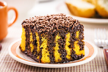 slice of carrot cake with creamy chocolate icing and sprinkles, typical of Brazilian June festivals, homemade cake