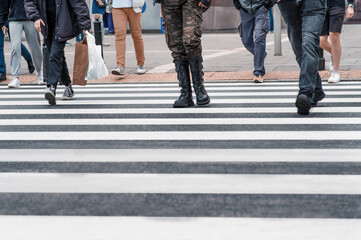 People crossing street in city, closeup view