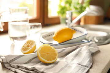 Halves of fresh ripe lemon on countertop in kitchen, space for text