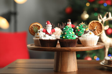 Many different Christmas cupcakes on wooden table indoors