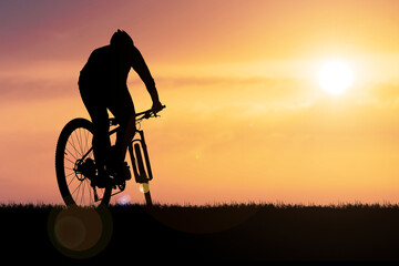 silhouette of a person riding a bike