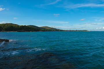 Rocky sea bach wave against blue sky