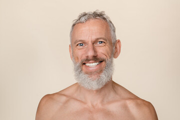 Smiling with toothy smile caucasian mature middle-aged shirtless man with grey hair and beard...