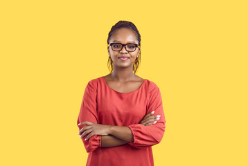 Portrait of young African American young woman isolated on yellow studio background look at camera. Millennial black girl in glasses demonstrate diversity and ethnicity. - obrazy, fototapety, plakaty