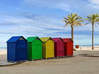 colorful dressers on the beach and palm trees in the background