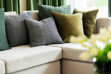 Close-up of beige earth tone pillow cushion set arrange on sofa couch in living room interior...