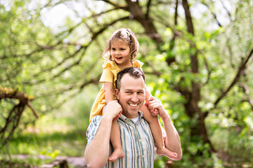 Father with his daughter having fun outside in forest