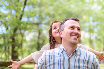 Fototapeta premium Father with his daughter having fun outside in forest