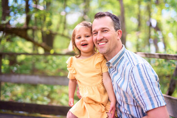 Fototapeta premium Father with his daughter having fun outside in forest