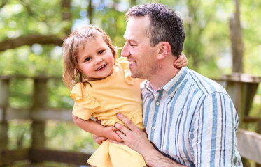 Father with his daughter having fun outside in forest