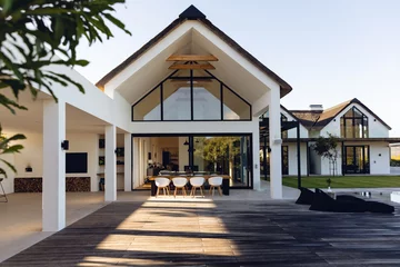 Deurstickers View of luxurious modern house exterior with dining space and garden © WavebreakMediaMicro