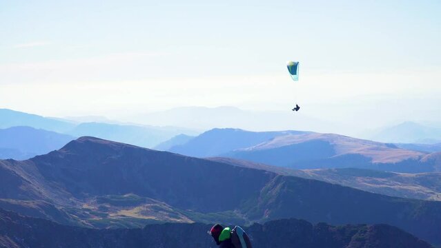 Paraglide athlete flying above the mountains