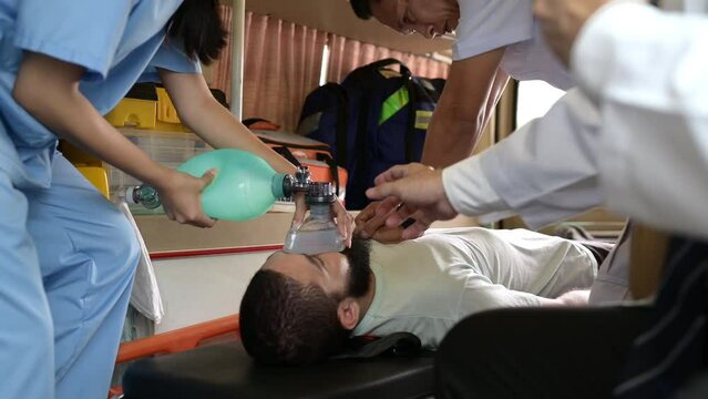 First aid assistance of the ambulance medical team with CPR method and hand-squeezed breathing apparatus