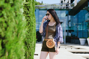 Portrait of young happy business woman relaxing in city. Drinking coffee. Using phone. technology. Social media. Video call. Summer vacation