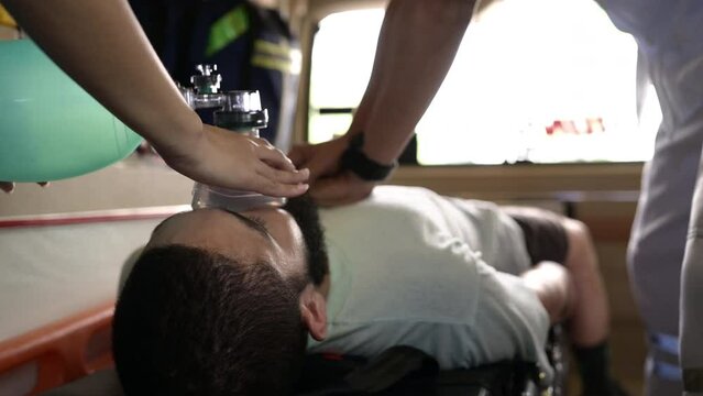 First aid assistance of the ambulance medical team with CPR method and hand-squeezed breathing apparatus