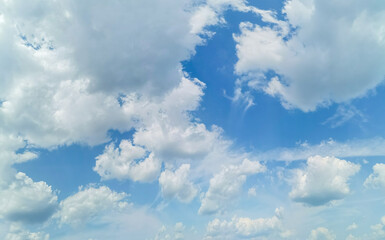 Beautiful summer blue sky with white fluffy clouds in midday.