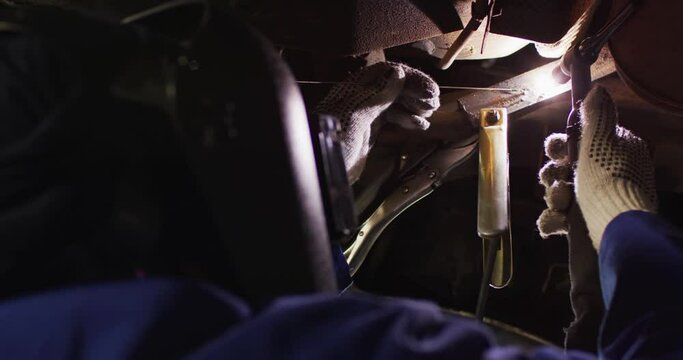 Video of caucasian female car mechanic welding car