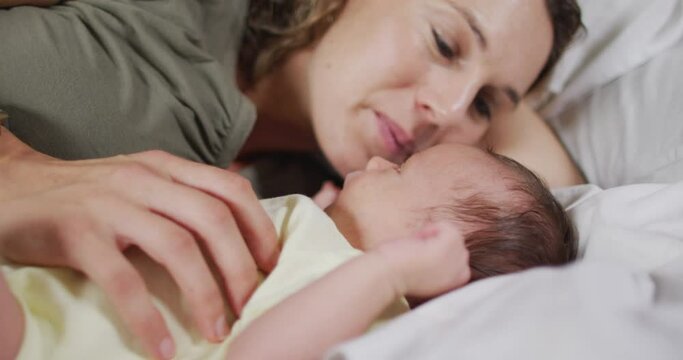 Video of happy caucasian mother kissing newborn baby